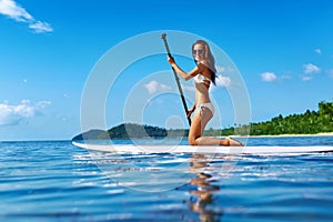 Recreational Water Sports. Woman Paddling On Surf Board. Summer