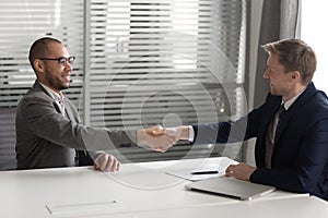 Recruiter shaking hand of African American candidate, successful job interview