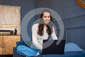 Recruitment concept. Excited woman browsing work opportunities online on laptop computer, sitting on sofa