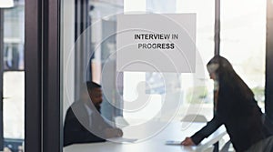 Recruitment, window sign and business people in an interview in the modern office boardroom. Hiring, meeting and