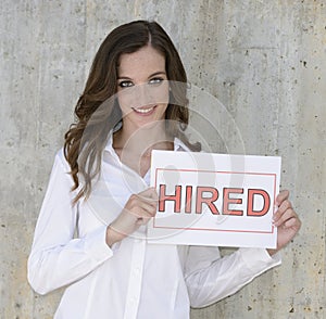 Recruitment : woman holding a hired sign