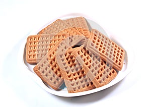 Rectangle shaped milk biscuits in a apple shaped food plate.