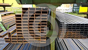 Rectangle Steel Tube in rows. Rectangular rusty pipe. Hot and cold rolled metal Tubing. Industrial metal supply. Warehouse and fac