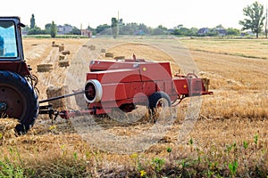Rectangular baler discharges straw bale in a field during the harvesting process