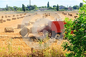 Rectangular baler discharges straw bale in a field during the harvesting process