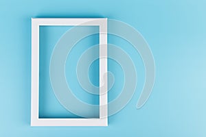 Rectangular blank white picture frame on the blue  background. mockup