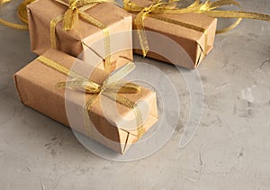 Rectangular box wrapped in brown paper and tied with a silk ribbon with a bow