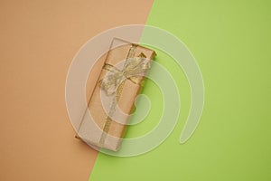 Rectangular box wrapped in brown paper and tied with a silk ribbon with a bow