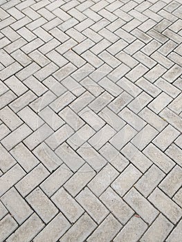 Rectangular cement block floor in zigzag pattern.