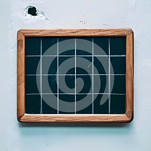 Rectangular chalkboard with grid pattern in wooden frame, slight wear and small hole