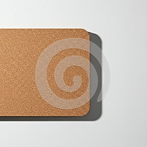 A rectangular cork board is positioned against a white surface. The board's texture