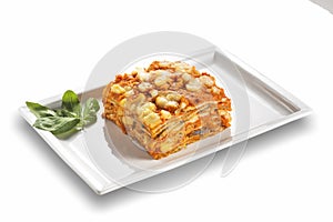 Rectangular dish with eggplant parmigiana with tomato cheese and basil leaves