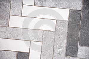 Rectangular floor tiles in white and gray tones