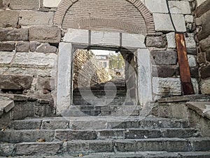 Rectangular gate in a stone wall in the ancient Ankara Castle in capital of Turkey. Stone steps and a wall of multi-colored huge