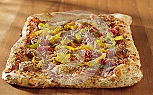 Rectangular gourmet pizza with sausage and colorfu