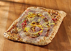 Rectangular gourmet pizza with sausage and colorfu