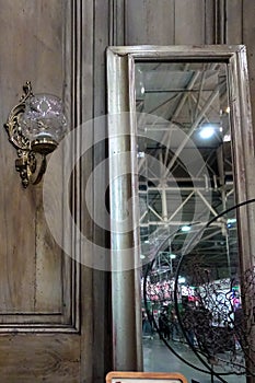 Rectangular mirror in a gray wooden frame near a vintage wardrobe