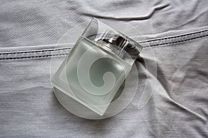 Rectangular perfume bottle on light grey jeans