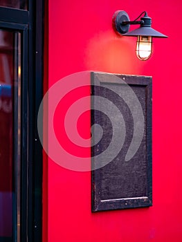 Rectangular real wooden painted sign with lighting from above. Chalkboard menu of cafe, restaurant or shop on city street on wall