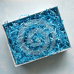 Rectangular White Box with Blue Crinkled Filler Shot from Above