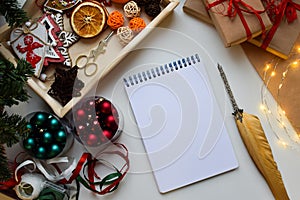 A rectangular white notebook lies on a white background surrounded by Christmas and New Year trifles