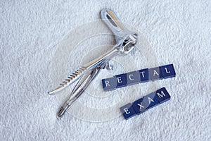Rectoscope with the words rectal exam on a white blanket