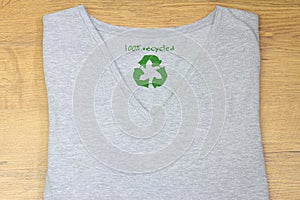 Recycle clothes icon on t shirt with 100% Recycled text