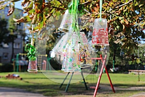 Recycle project of plastic bottles and cups, colored with different colors. Second life for plastic. Kids project in the