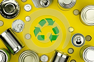 Recycle reuse sign symbol with metal aluminium cans, covers, jars