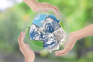 Recycle symbol and Earth in hands over green nature background