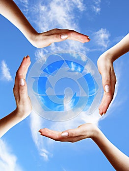 Recycle symbol in a hands circle on sky background