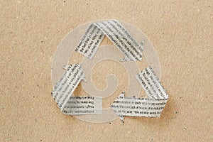 Recycle symbol made with newspaper sheet on recycled paper - Ecology and recycling concept