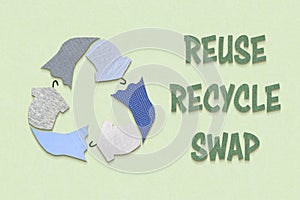 Recycle textiles symbol made from old clothing fabric on green background photo