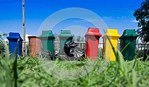 Recycle waste bins and black plastic bag on grass