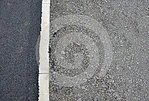 Recycled asphalt crumb is used on the edge of the new cycle path and in the subsoil of the asphalt road. between the field and the photo