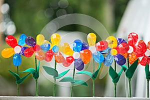 Recycled colorful plastic flowers in pot.