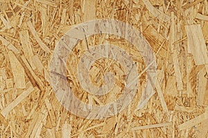 Recycled compressed wood chippings board, strand board close-up, fiberboard texture, wooden background