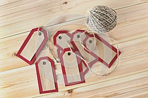 Recycled craft paper red tags and rope on vintage wooden table background. Top view. Mock up sample.
