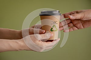 Recycled Packaging Concept. Closeup of Barista Giving a Hot Cup of Coffee to customer. Zero Waste Materials. Environment Care,