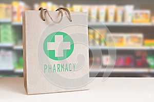 Recycled paper bag with a green Pharmacy logo in a drugstore. Empty copy space