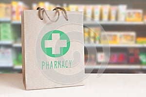 Recycled paper bag with a green Pharmacy logo in a drugstore. Empty copy space photo