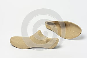 Recycled paper shoe stretcher on white background.