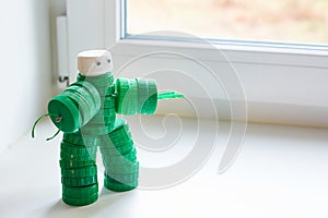 Recycling art. Zero waste, the second life of things. Toy robot made of plastic caps on the window. copyspace