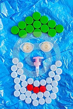 Recycling. Creative use of plastic waste. Polluted environments. Face mede of bottle caps