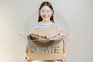 Recycling, Donation for poor, smiling asian young woman pack, holding donate box full with second hand clothes, charity helping