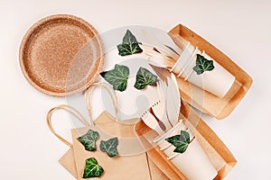 Recycling,eco-friendly concept.Disposable eco cutlery,plates,spoons,knives,forks on a light background.Craft paper bag