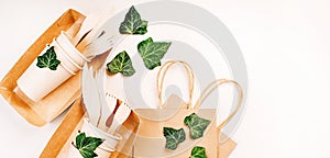 Recycling,eco-friendly concept.Disposable eco cutlery,plates,spoons,knives,forks on a light background.Craft paper bag