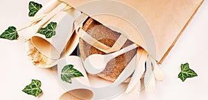 Recycling,eco-friendly concept.Disposable eco cutlery,plates,spoons,knives,forks on a light background.Craft paper bag