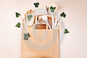 Recycling,eco-friendly concept.Disposable eco cutlery,plates,spoons,knives,forks on a light background.Craft paper bag