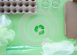 Recycling. Green recycle eco symbol. Recycled arrows sign near materials for recycle and reuse cardboard, glass bottle